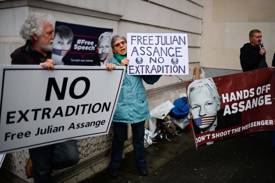 Supporters of Wikileaks founder Julian Assange hold placards outside Westminster Magistrates Court in London on December 19, 2019. The legal team of WikiLeaks founder Julian Assange's will argue he should not be extradited to the US because his alleged offenses are being framed as "political" in nature, a court heard. 