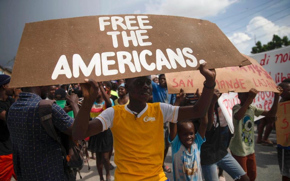 People protest for the release of kidnapped missionaries near the Ohio-based Christian Aid Ministries headquarters in Titanyen, north of Port-au-Prince - AP