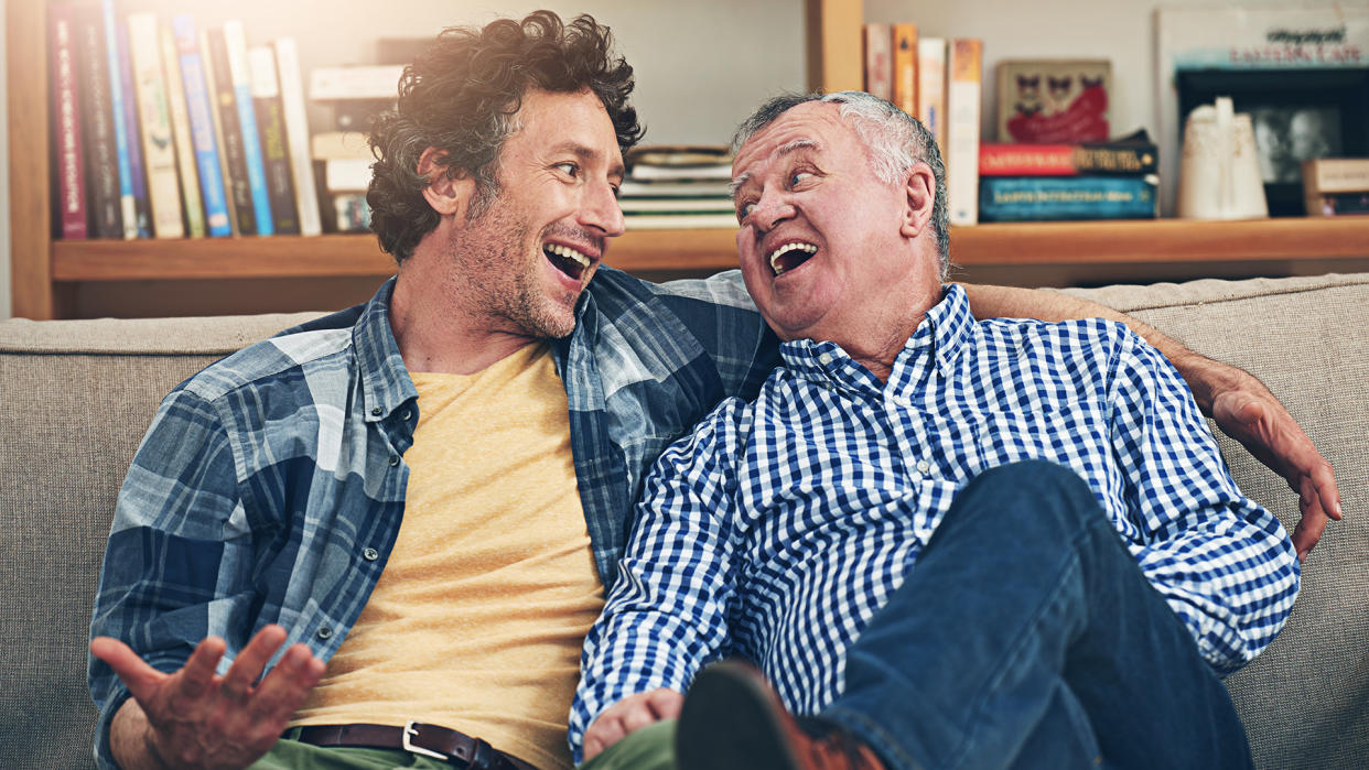 Shot of a mature man and his elderly father sitting on the sofa at home and having a chat.