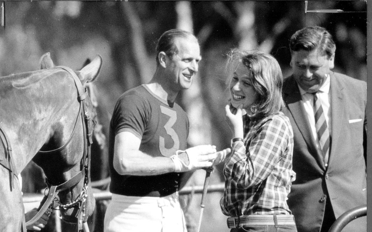 Wearing wild west jeans and check shirt Princess Anne has a joke with Prince Philip between chukkas at Smith's Lawn,Windsor Great Park