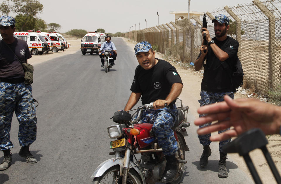 Security guards rush to the scene to take up their positions around a training center for airport security personnel in Karachi, Pakistan, Tuesday, June 10, 2014. Gunmen in Pakistan attacked a training facility near the Karachi airport on Tuesday, a spokesman said. The facility is roughly one kilometer (half mile) from the Karachi international airport. (AP Photo/Shakil Adil)