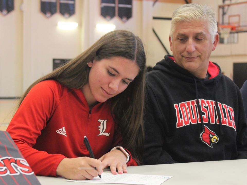 Taunton softball's Ava Venturelli signs her National Letter of Intent to play for the University of Louisville as dad Tony Venturelli watches on during a signing ceremony on Nov. 14, 2022.