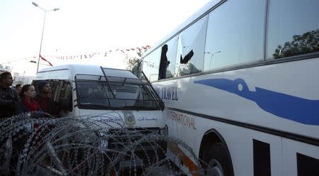 People look at a bus damaged by an attack by gunmen on Tunisia's national museum, in Tunis March 18, 2015. REUTERS/Zoubeir Souissi