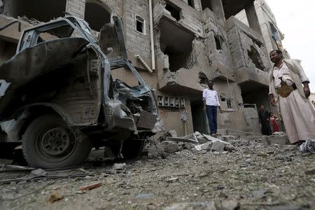 People stand at the site of a Saudi-led air strike in Yemen's capital Sanaa August 30, 2015. REUTERS/Khaled Abdullah