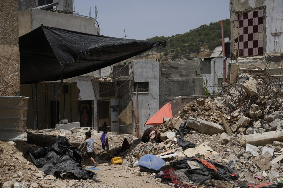 Palestinian children play by the rubble of buildings that were destroyed during Israeli army operations in the Nur Shams refugee camp in the West Bank on May 20, 2024. (AP Photo/Nasser Nasser)