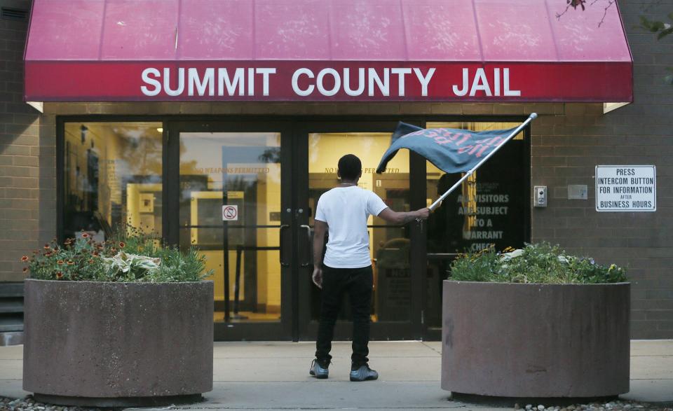 James Crawl, 25, waves a "No Justice No Peace" flag outside Summit County Jail during a protest of activist arrests over the Fourth of July weekend. Crawl wrestled at Buchtel high school with Jayland Walker, whose shooting death by Akron police has prompted days of protests.