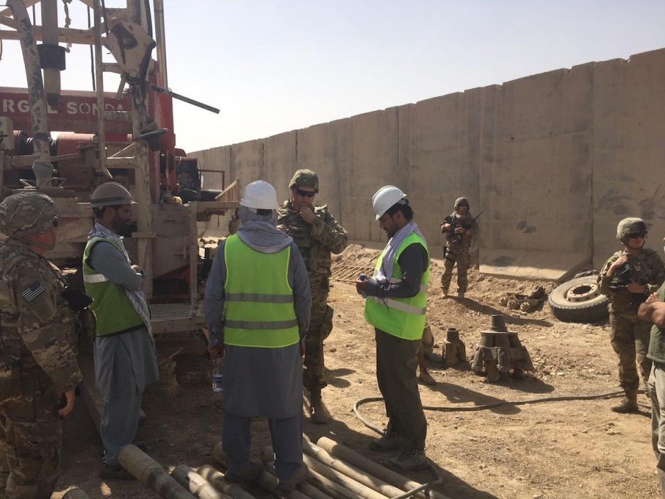Construction Control Representative, James Fielden, Local National Quality Assurance Representative, and Project Engineer Brian Cagle USACE Afghanistan District discuss the Drilling operations of a new Water Well with the contractors at the Kandahar Air Wing Waste & Water Treatment Project