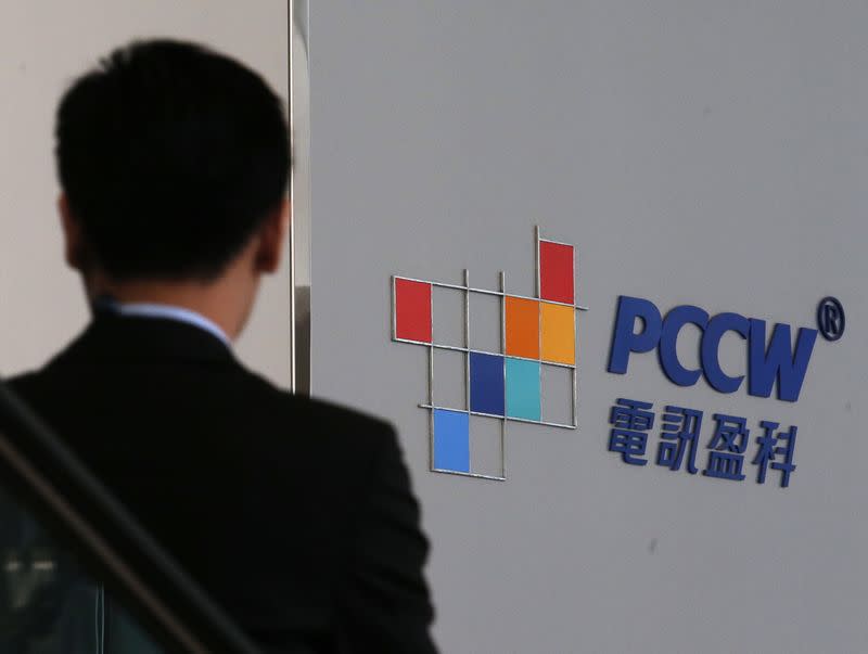 A man descends in an escalator at the PCCW headquarters in Hong Kong