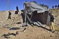 Pakistani security officials inspect a damaged truck at the site of suicide bombing on the outskirts of Quetta, Pakistan, Wednesday, Nov. 30, 2022. A suicide bomber blew himself up near a truck carrying police officers on their way to protect polio workers outside Quetta, wounding more than 20 others, mostly policemen, officials said. (AP Photo/Arshad Butt)