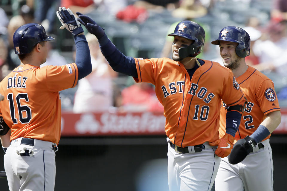 Houston Astros' Yuli Gurriel, center, gets congratulations from Aledmys Diaz, left, after hitting a two-run home run to also score Alex Bregman, right, during the third inning of a baseball game against the Los Angeles Angels in Anaheim, Calif., Sunday, Sept. 29, 2019. (AP Photo/Alex Gallardo)