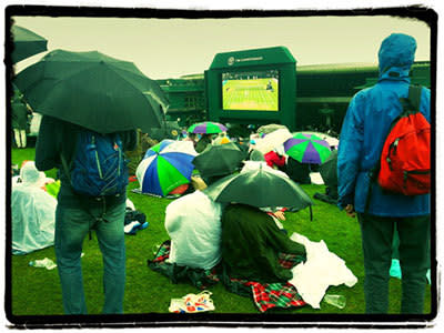 <p>Fans watch a re-run of an earlier match as they wait for the rain to stop at The Wimbledon Lawn Tennis Championships on June 28, 2013 in London, England.</p>