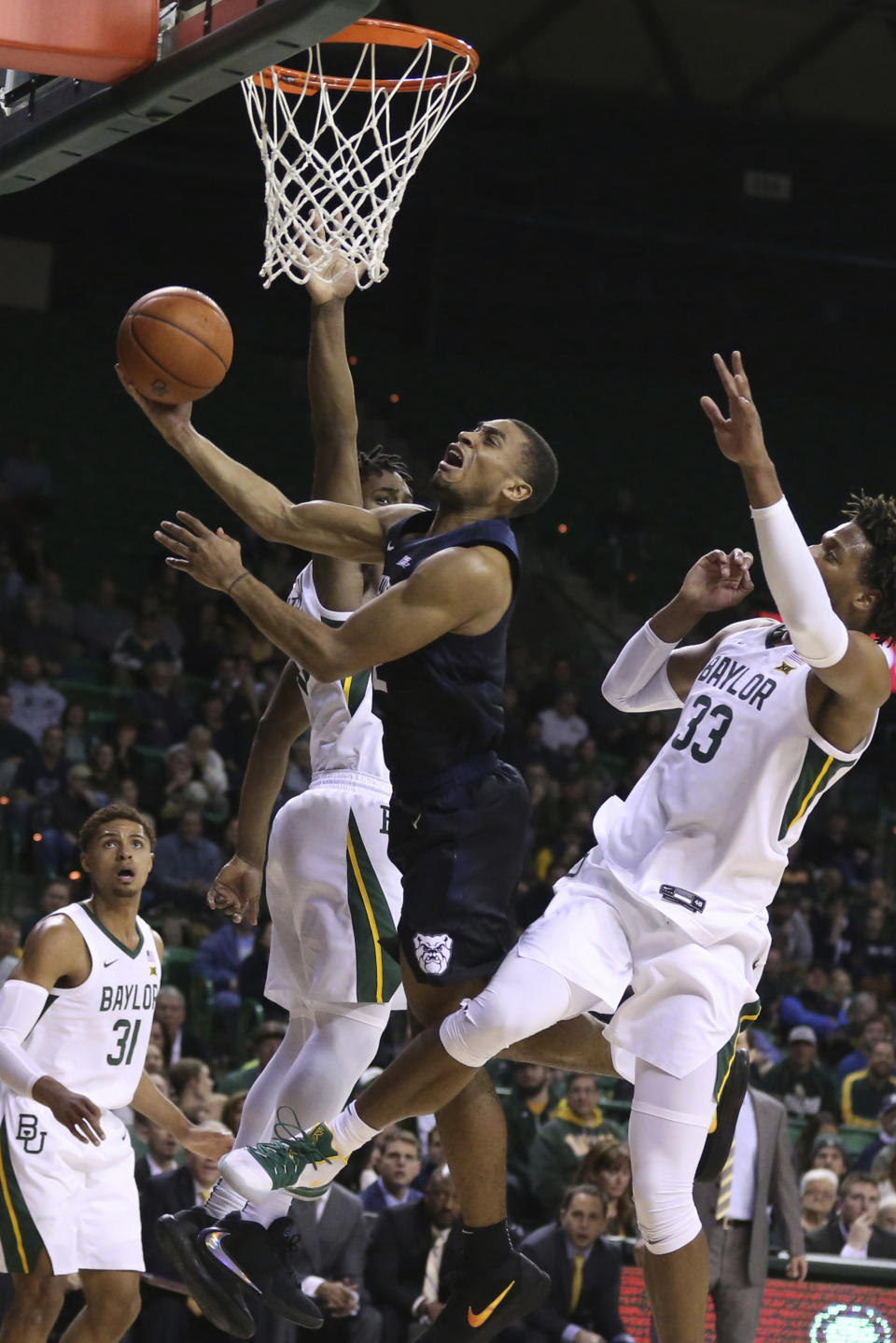 Butler guard Aaron Thompson, center, drives between Baylor guard Davion Mitchell, left, and forward Freddie Gillespie, right, in the first half of an NCAA college basketball game, Tuesday, Dec. 10, 2019, in Waco, Texas. (AP Photo/Rod Aydelotte)