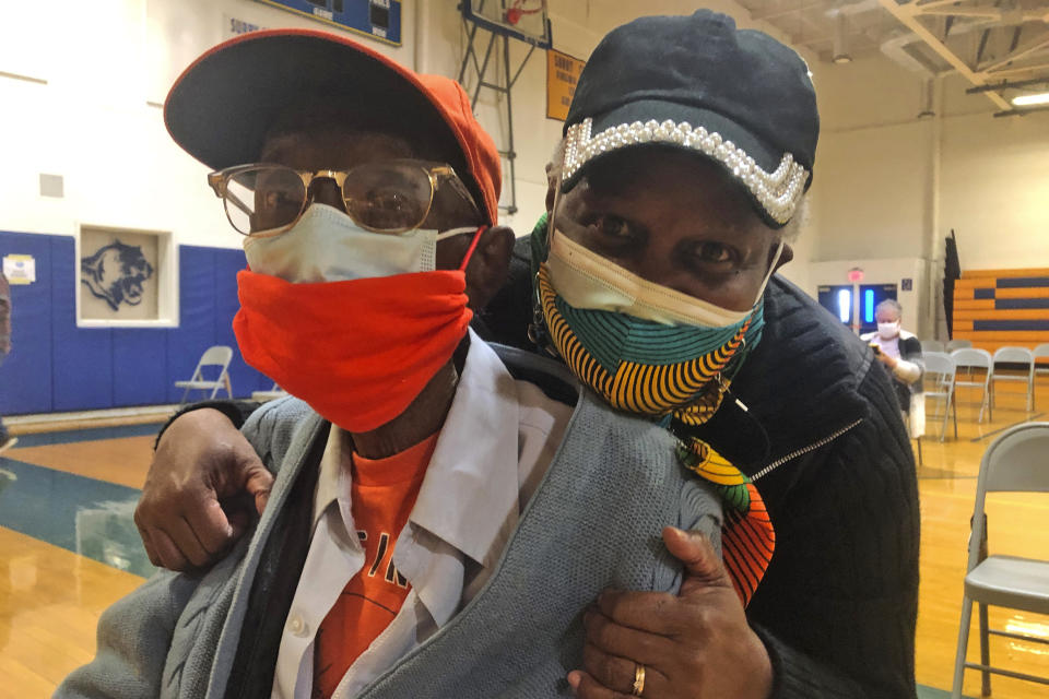 Charles Robbins celebrates with his daughter Charlome Pierce, right, after getting his second shot of coronavirus vaccine at Surry County High School in Dendron, Va., on Saturday, Feb. 27, 2021. Getting the coronavirus vaccine has been a challenge for rural counties in the U.S. that lack medical facilities such as a pharmacy or a well-equipped doctor's office. Pierce and her father were relieved to get their second shots in late February. (AP Photo/Ben Finley)