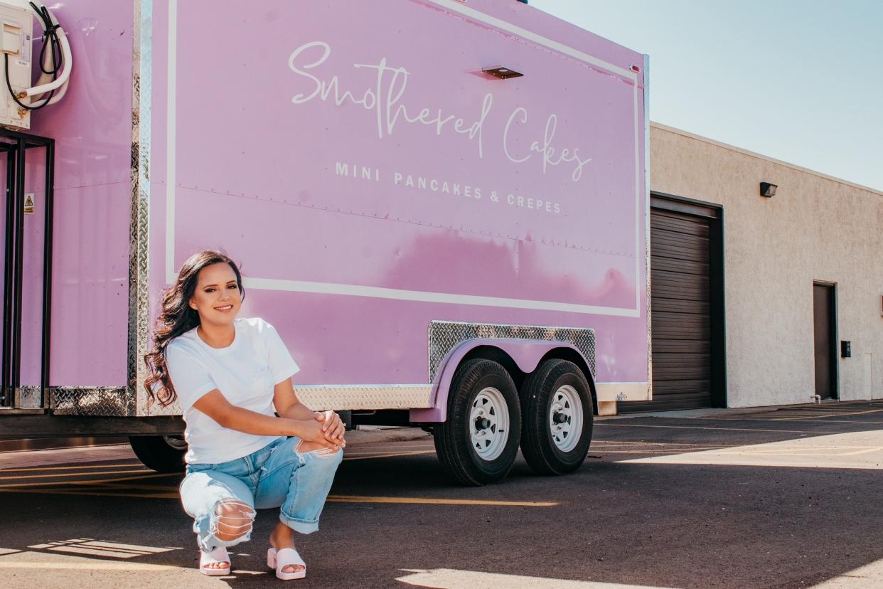 Alexsis Gonzalez, owner of Smothered Cakes, poses in front of her upcoming food truck, which will open in Lubbock on Sunday, Aug. 6, 2023.
