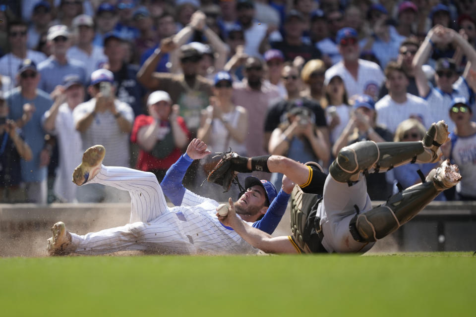 Chicago Cubs' Cody Bellinger scores the winning run past Pittsburgh Pirates catcher Joey Bart off a single by Christopher Morel during the ninth inning of a baseball game Saturday, May 18, 2024, in Chicago. (AP Photo/Charles Rex Arbogast)