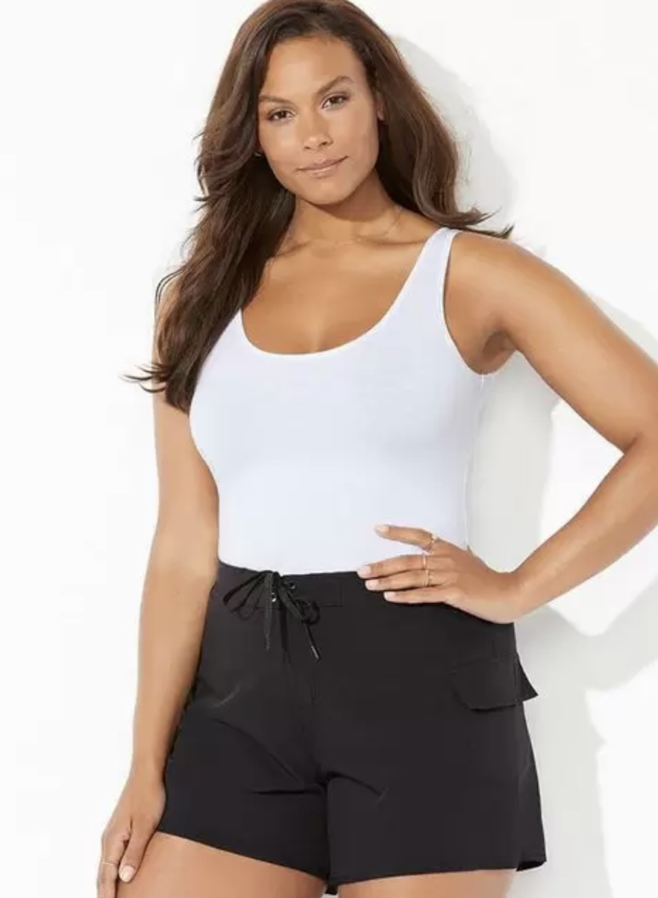 plus size model in white tank top and black Stretch Board Short (Photo via Swimsuits For All)