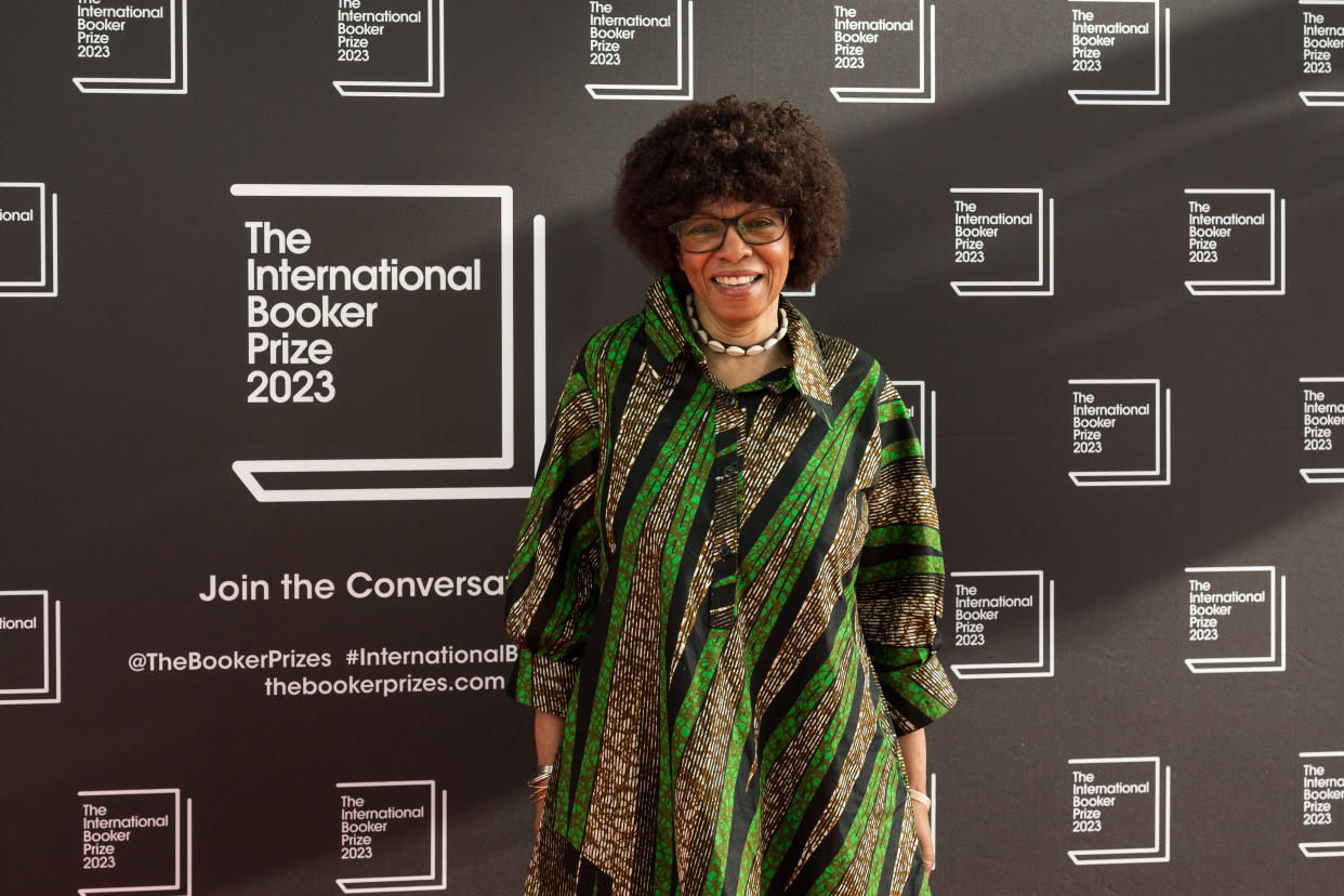 Margaret Busby CBE, wearing a boldly patterned green and black collared dress, smiles as she attends the official winners ceremony of the International Booker Prize 2023 at the Sky Garden in London, United Kingdom