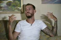 Jihad Michlawi, 31, speaks during an interview with The Associated Press at his home in the northern Beirut suburb of Burj Hammoud, Lebanon, Tuesday, Sept. 27, 2022. Michlawi is one of dozens of survivors from a migrant boat that left Tripoli, Lebanon heading towards Italy carrying over 100 Lebanese, Syrians, and Palestinians, that capsized near the Syrian coastal city of Tartus. At least 94 people were killed. (AP Photo/Bilal Hussein)