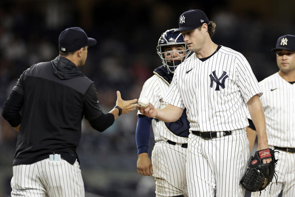 New York Yankees pitcher Gerrit Cole hands the ball to manager Aaron Boone during the seventh inning of the second baseball game of a doubleheader against the Minnesota Twins on Wednesday, Sept. 7, 2022, in New York. (AP Photo/Adam Hunger)