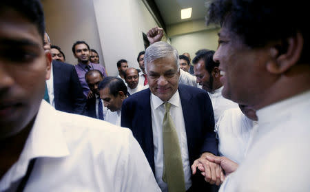 Sri Lankan Prime Minister Ranil Wickremesinghe (C) shakes hands with his party members who supported him after he survived a no confidence vote in parliament in Colombo, Sri Lanka April 4,2018.REUTERS/ Dinuka Liyanawatte