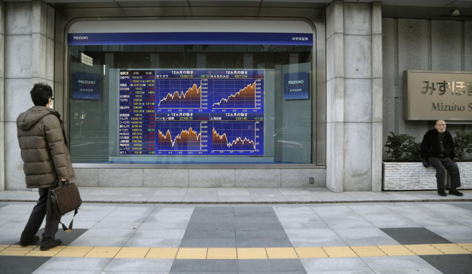 A man looks at an electronic stock board of a securities firm in Tokyo, Thursday, March 6, 2014. Shares were mostly higher in Asia on Thursday as the standoff over Ukraine between Russia and the West continued to ease and the yen weakened. (AP Photo/Koji Sasahara)