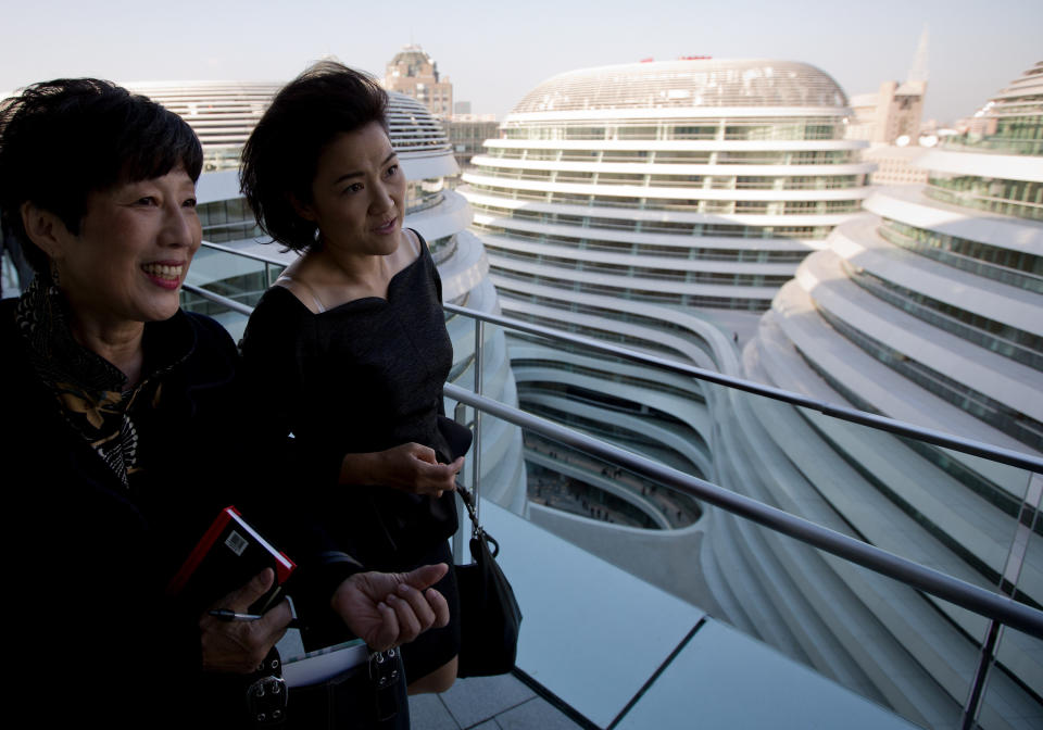 Soho China CEO Zhang Xin, second from left, walks with a guest as they tour the newly opened Galaxy Soho building in Beijing Saturday, Oct. 27, 2012. Galaxy Soho, a new office, retail and entertainment building, designed by Iraqi-British architect Zaha Hadid, winner of the Pritzker Architecture Prize in 2004, and the Stirling Prize in 2010 and 2011. (AP Photo/Andy Wong)