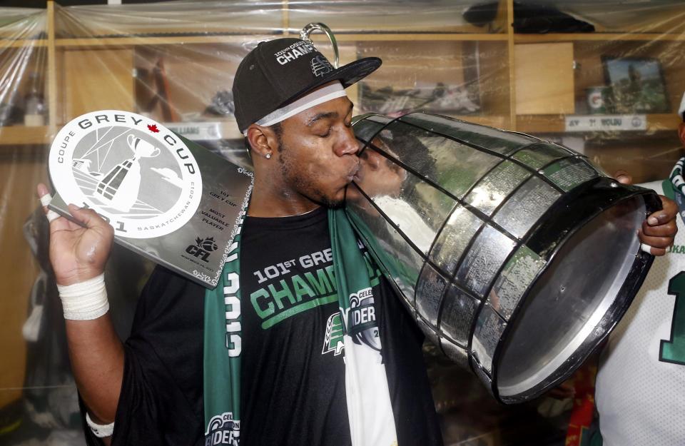 The Saskatchewan Roughriders Kory Sheets kisses the Grey Cup while holding his MVP trophy after they defeated the Hamilton Tiger-Cats in the CFL's 101st Grey Cup championship football game in Regina, Saskatchewan November 24, 2013. REUTERS/Mark Blinch (CANADA - Tags: SPORT FOOTBALL)