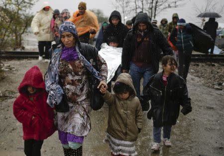 Migrants walk under rain after crossing the border from Greece into Macedonia, near Gevgelija, Macedonia, November 27, 2015. REUTERS/Stoyan Nenov