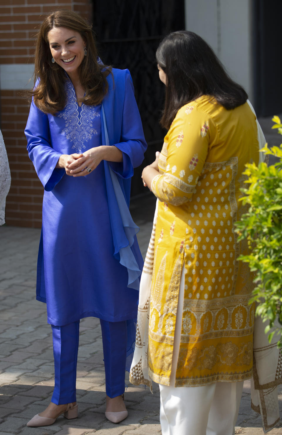 Britain's Princess Kate wears the traditional Pakistani dress called a Kurta as she speaks to a school teacher during her visit to school outside Islamabad, Pakistan, Tuesday, Oct. 15, 2019. The Duke and Duchess of Cambridge, who are strong advocates of girls' education were greeted by teachers and children. (AP Photo/B.K. Bangash)