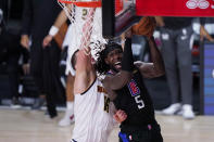 Los Angeles Clippers forward Montrezl Harrell (5) drives to the basket Denver Nuggets center Nikola Jokic (15) during the second half of an NBA conference semifinal playoff basketball game Tuesday, Sept. 15, 2020, in Lake Buena Vista, Fla. (AP Photo/Mark J. Terrill)