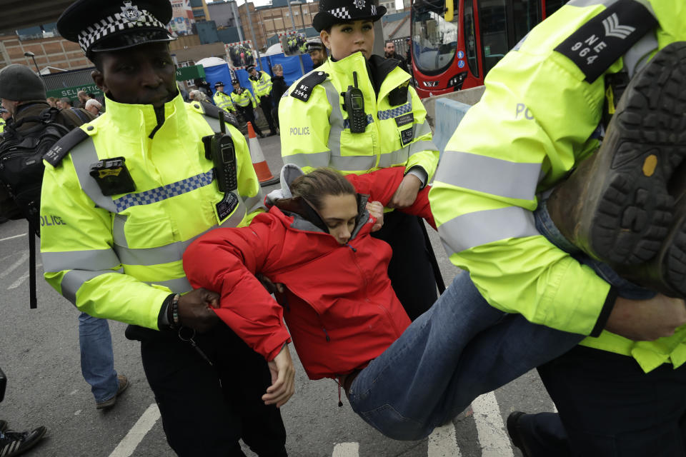 An Extinction Rebellion climate change protester is removed by police from blocking a road outside City Airport in London, Thursday, Oct. 10, 2019. Some hundreds of climate change activists are in London during a fourth day of world protests by the Extinction Rebellion movement to demand more urgent actions to counter global warming. (AP Photo/Matt Dunham)