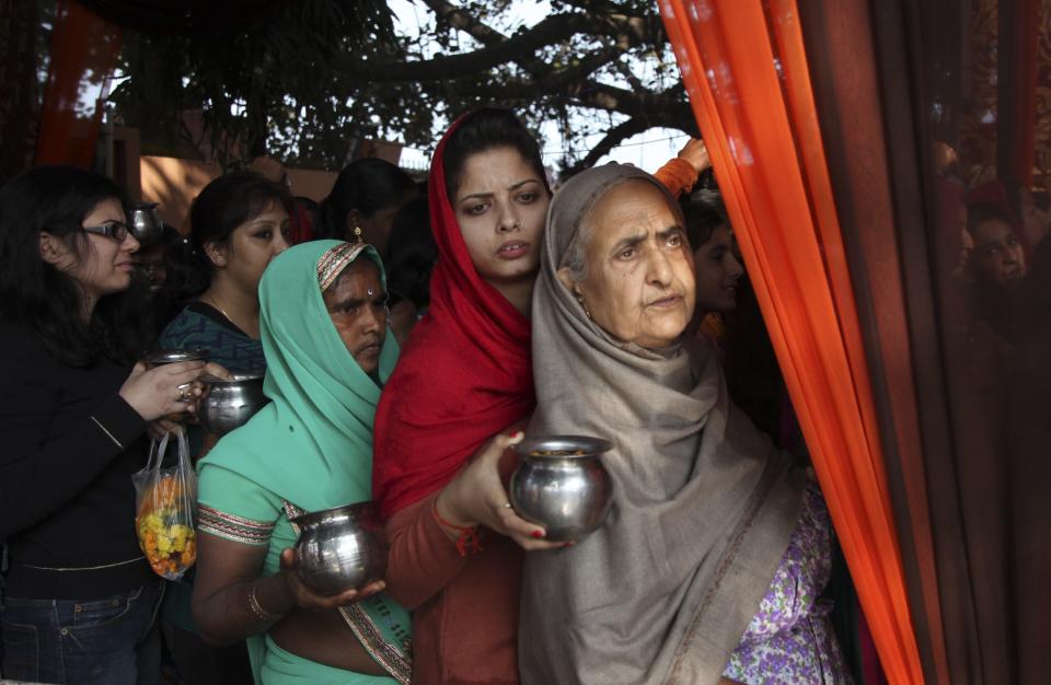 Hindu devotees wait their turn to offer prayers at the Aap Shambhu Lord Shiva temple during "Shivaratri" festival in Jammu, India, Tuesday, Feb.17, 2015. 