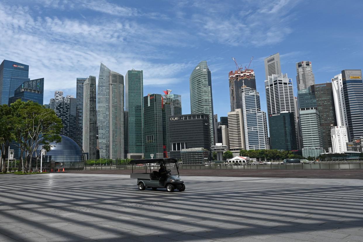 A driver operates a buggy along the Marina Bay promenade, as the city skyline is seen in the background, in Singapore on March 31, 2021. (Photo by Roslan RAHMAN / AFP) (Photo by ROSLAN RAHMAN/AFP via Getty Images)