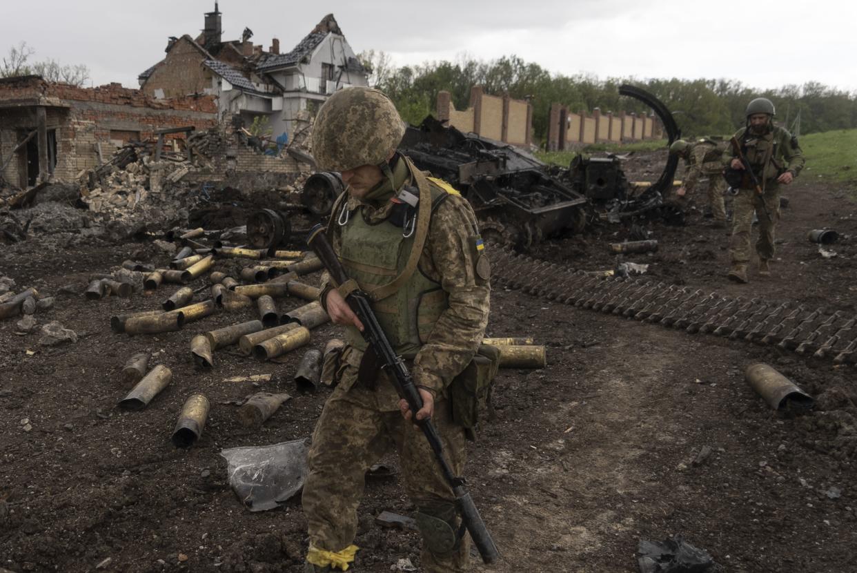 Ukrainian servicemen patrol in a recently retaken village, north of Kharkiv, east Ukraine, Sunday, May 15, 2022. 