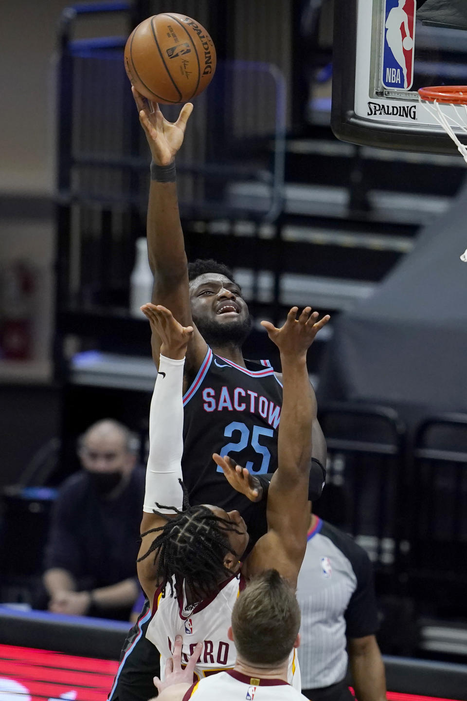 Sacramento Kings forward Chimezie Metu (25) shoots as Cleveland Cavaliers forward Isaac Okoro, middle, and forward Dean Wade defend during the first half of an NBA basketball game in Sacramento, Calif., Saturday, March 27, 2021. (AP Photo/Jeff Chiu)