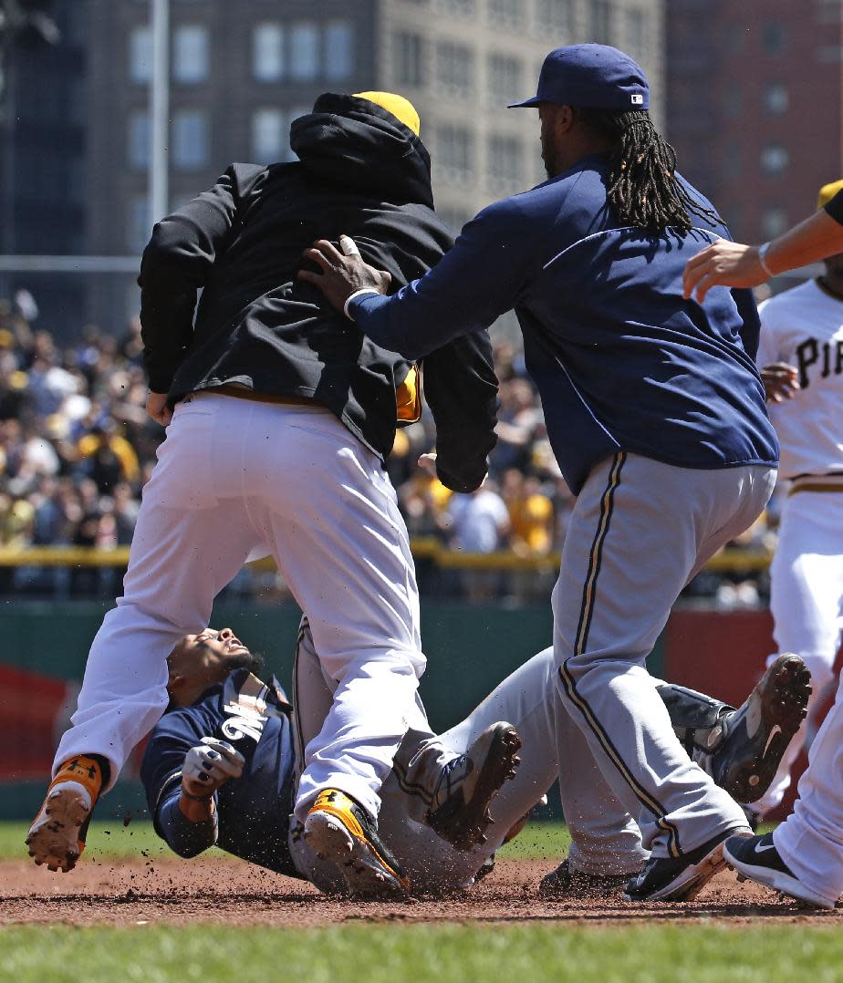 Pittsburgh Pirates' Travis Snider, left, takes down Milwaukee Brewers' Carlos Gomez, bottom, as Brewers' Rickie Weeks, right, joins a skirmish between the teams during the third inning of a baseball game in Pittsburgh, Sunday, April 20, 2014. Gomez and Snider were ejected from the game. (AP Photo/Gene J. Puskar)