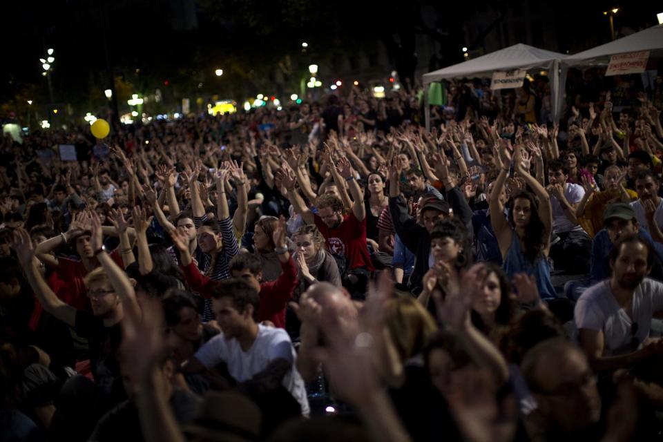 Demonstrators rise their hands as they take part in a protest to mark the anniversary of the beginning of the "Indignados" movement in Barcelona, Spain, Saturday May 12, 2012. Spanish activists angered by grim economic prospects planned nationwide demonstrations Saturday to mark the one-year anniversary of their protest movement that inspired similar groups in other countries. The protests began May 15 last year and drew hundreds of thousands of people calling themselves the Indignant Movement. The demonstrations spread across Spain and Europe as anti-austerity sentiment grew. (AP Photo/Emilio Morenatti)