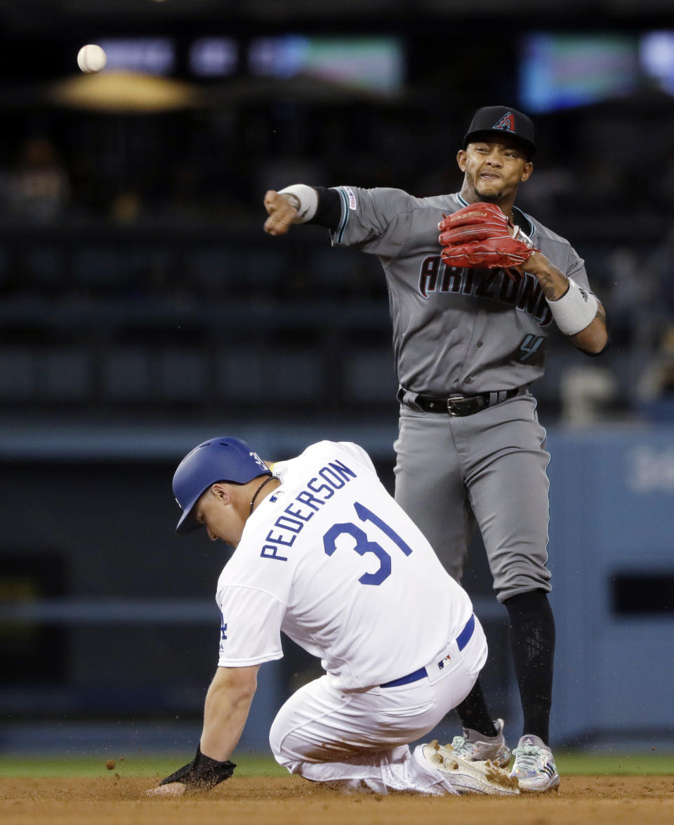 Arizona Diamondbacks shortstop Ketel Marte, top, throws to first after forcing out Los Angeles Dodgers' Joc Pederson (31) at second base on a ground ball by Russell Martin, who was safe at first during the sixth inning of a baseball game Friday, March 29, 2019, in Los Angeles. (AP Photo/Marcio Jose Sanchez)