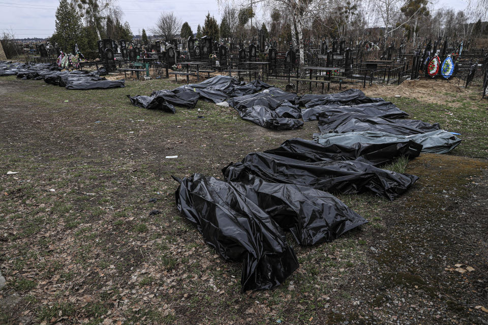 BUCHA, UKRAINE - APRIL 10: (EDITORS NOTE: Image depicts death) Officials exhume the bodies of civilians who died during the Russian attacks, from mass graves, backyard of St. Andrea's Church in Bucha, Ukraine on April 10, 2022. (Photo by Metin Aktas/Anadolu Agency via Getty Images)