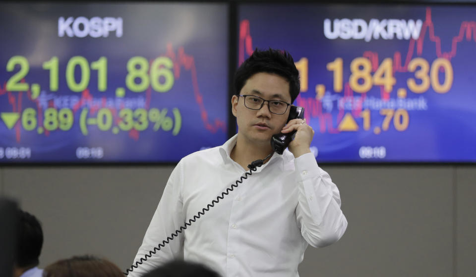 A currency trader talks on the phone near the screens showing the Korea Composite Stock Price Index (KOSPI), left, and the foreign exchange rate between U.S. dollar and South Korean won at the foreign exchange dealing room in Seoul, South Korea, Thursday, June 13, 2019. Asian stocks were mixed on Thursday as protesters in Hong Kong vowed to keep opposing a proposed extradition bill they fear would whittle down the territory’s legal autonomy. (AP Photo/Lee Jin-man)