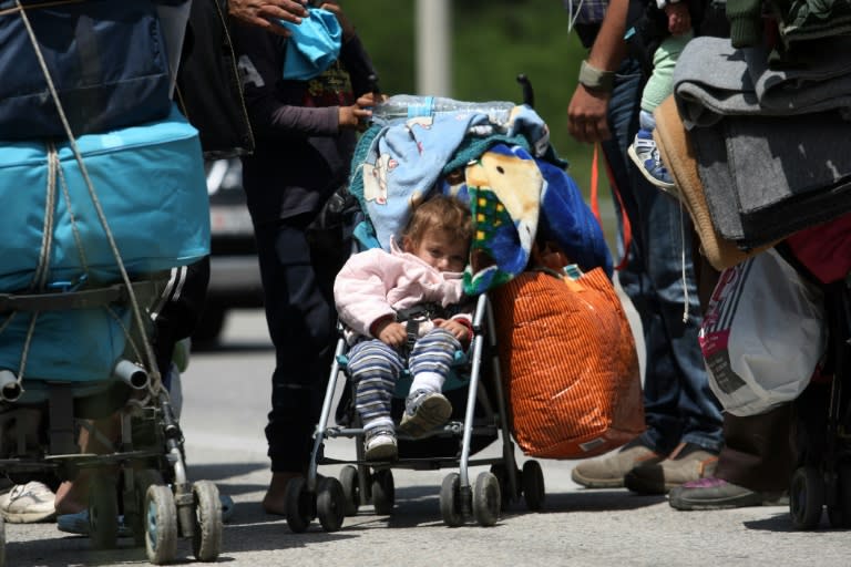 Migrant families leave the Idomeni camp on foot on May 25, 2016 because they do not want to be bussed to another camp