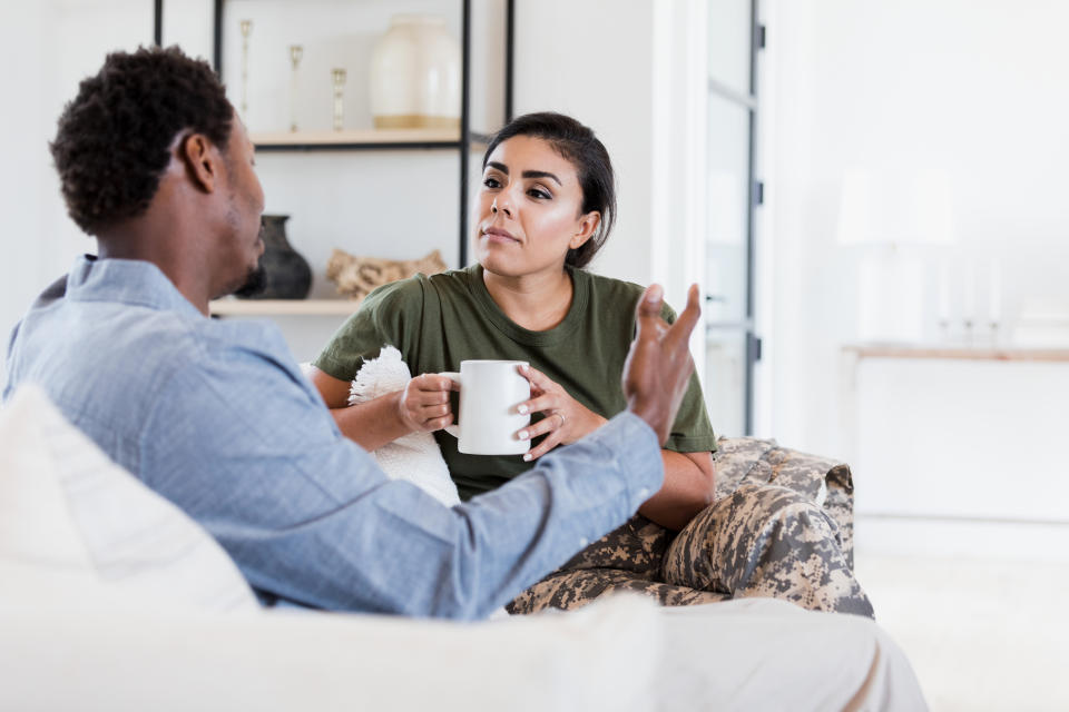 An attentive female soldier listens as her husband discusses something serious.