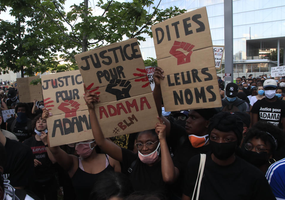FILE - In this Tuesday, June 2, 2020 file photo people protest with posters reading "Justice for Adama" outside the Palace of Justice in Paris. The demonstrators declared "We are all George Floyd," but also invoked the name of Adama Traore, a 24-year-old Frenchman of Malian origin who died in police custody in 2016. The circumstances are still under investigation by justice authorities. (AP Photo/Michel Euler, File)