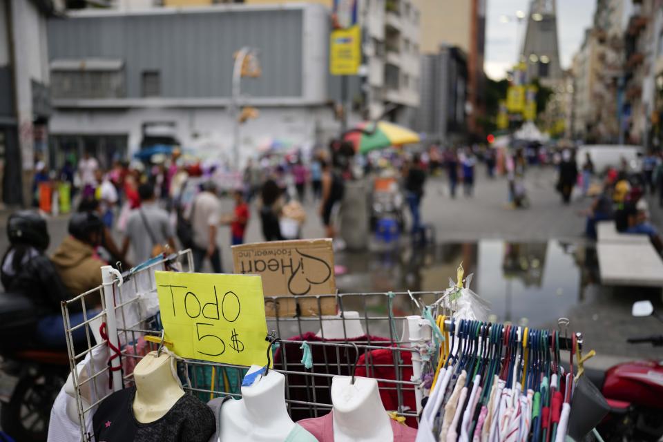 FILE - A sign announces "All for five dollars" on a rack outside a store in Caracas, Venezuela, Oct. 3, 2023. (AP Photo/Matias Delacroix, File)
