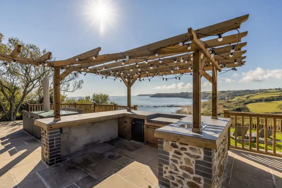 <p>With an excellent position on the Lizard, this holiday let's remote setting is close to a private beach in seven acres of private land. The secluded Airbnb beach house with five bedrooms has some incredible features, including an outdoor kitchen, a hot tub overlooking the dramatic Lizard Peninsula and plenty of outside space for younger guests to run around.</p><p><strong>Why we love it:</strong> The outdoor kitchen for alfresco feasts with a view.</p><p><strong>Sleeps: </strong>10</p><p><a class="link " href="https://airbnb.pvxt.net/x9DYaO?trafcat=summer" rel="nofollow noopener" target="_blank" data-ylk="slk:CHECK AVAILABILITY">CHECK AVAILABILITY</a></p>