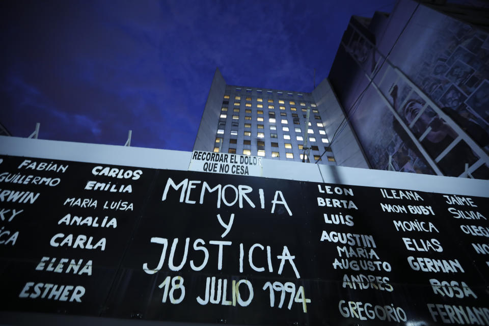 A sign reading in Spanish "Memory and Justice" and the names of those who died during the bombing of the AMIA Jewish center that killed 85 people is displayed outside the site of the attack on the 25th anniversary of the bombing in Buenos Aires, Argentina, Thursday, July 18, 2019. (AP Photo/Natacha Pisarenko)