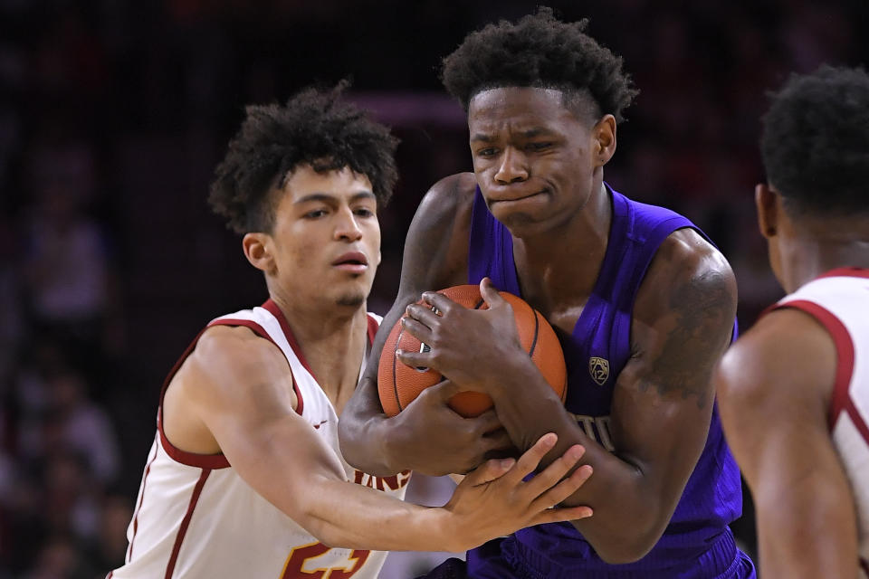 Southern California forward Max Agbonkpolo, left, ties up Washington guard Nahziah Carter during the first half of an NCAA college basketball game Thursday, Feb. 13, 2020, in Los Angeles. (AP Photo/Mark J. Terrill)