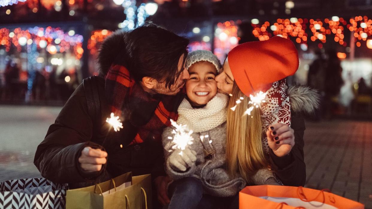 cute couple with sparklers wishing happy new year to the little daughter