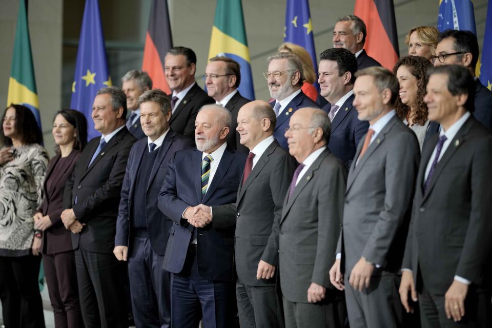 Luiz Inacio Lula da Silva, President of Brazil and German Chancellor Olaf Scholz shake hands surrounded by their cabinet members during a family photo at a German and Brazil governments meeting at the chancellery in Berlin, Germany, Monday, Dec. 4, 2023. (AP Photo/Markus Schreiber)