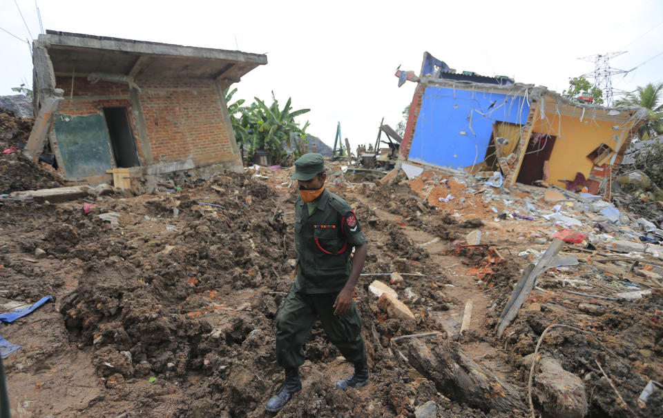 A Sri Lankan army soldier walks past damage houses after garbage collapse in Meetotamulla, on the outskirts of Colombo, Sri Lanka, Colombo, Sri Lanka, Monday, April 17, 2017. Rescuers on Monday were digging through heaps of mud and trash that collapsed onto a clutch of homes near a garbage dump outside Sri Lanka's capital, killing dozens and possibly burying dozens more. (AP Photo/Eranga Jayawardena)